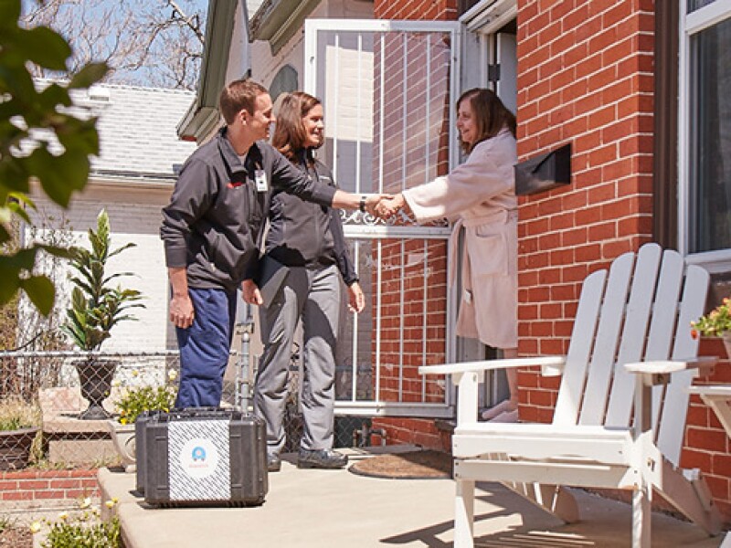 DispatchHealth providers meeting patient at the front door of her home